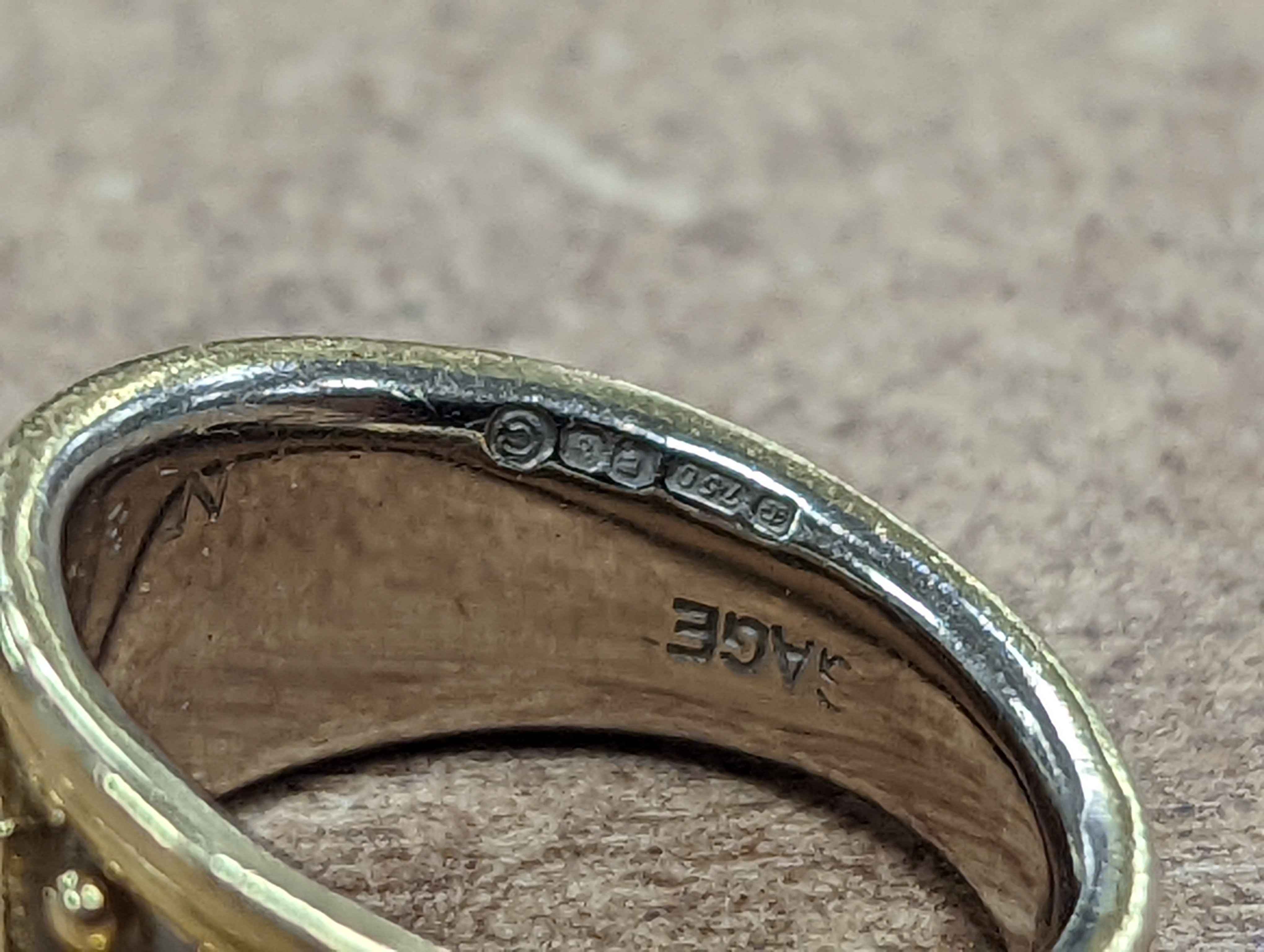 A modern two colour 18ct gold and three stone diamond set dress ring by Elisabeth Gage, size K/L, gross weight 7 grams, with engraved date to shank interior.
